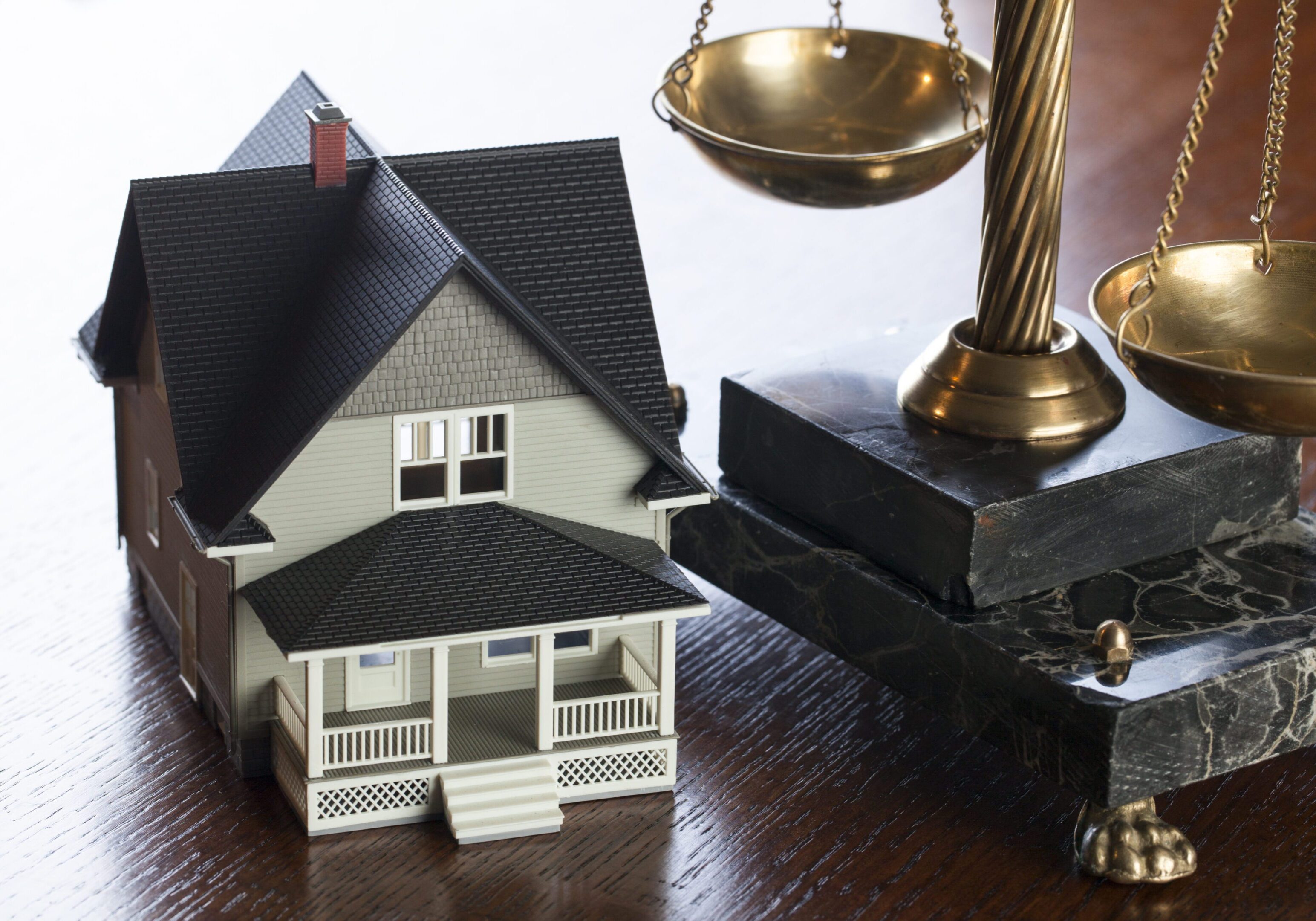 House model beside scales of justice.