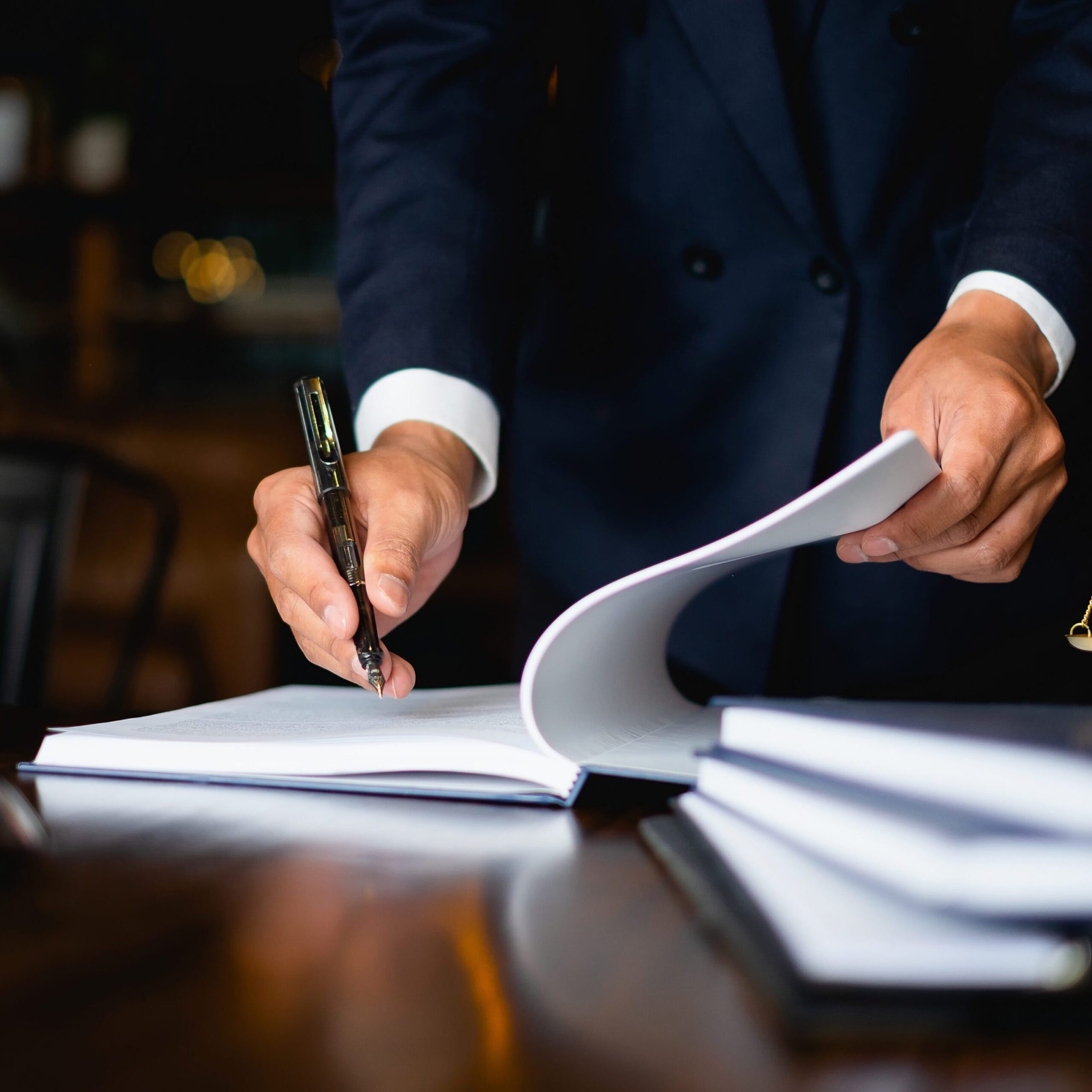 Lawyer signing documents in an office.